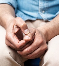 Man feeling anxious and picking at finger nails, needing Anxiety Therapy in Peoria IL
