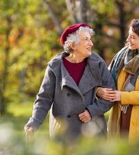Elderly woman happily walking with daughter