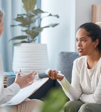 A woman talking with a counselor, discussing Women's Issues in Peoria IL