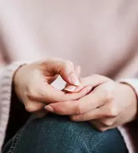 A woman holding hands uncomfortably, wanting therapy in Peoria IL
